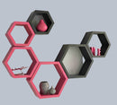 Hexagonal wall shelves in black and pink on a light gray wall.