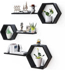Hexagonal black wall shelves with decorative items on a white background